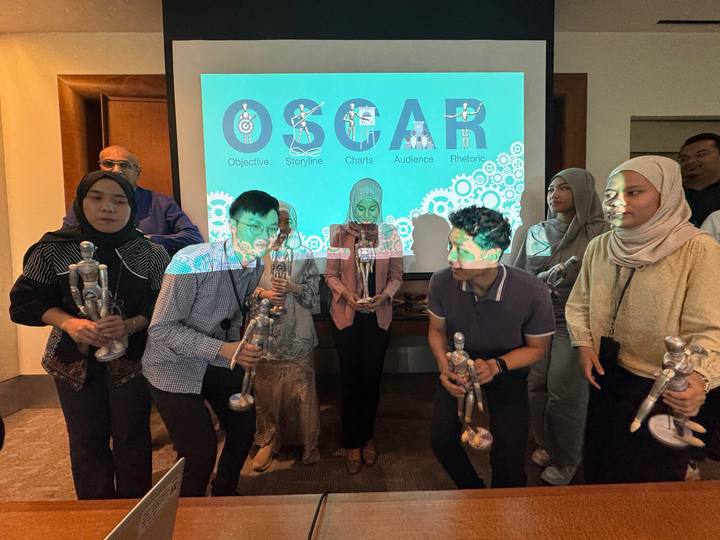 A workshop group holding their OSCAR figurines