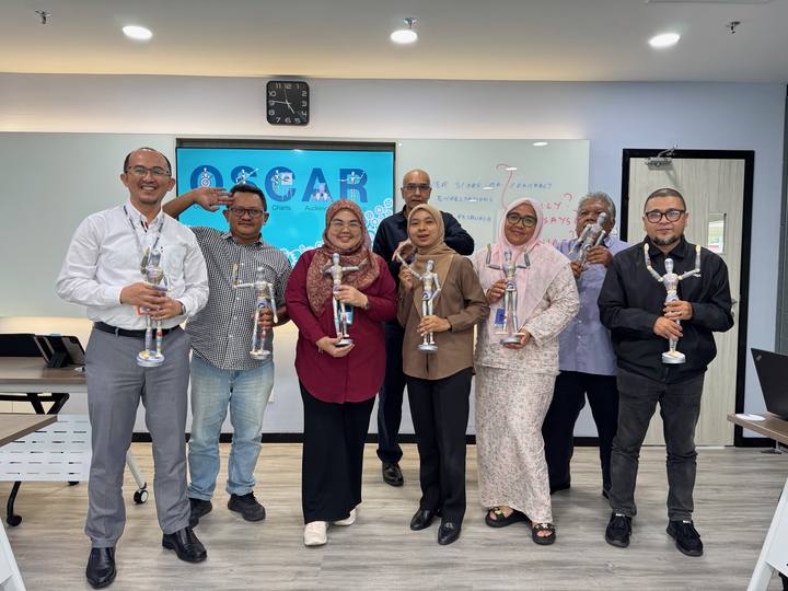 A workshop group holding their OSCAR figurines